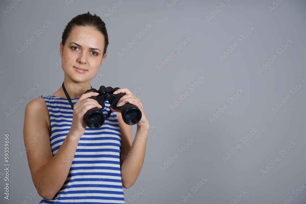 girl with binoculars isolated on grey background