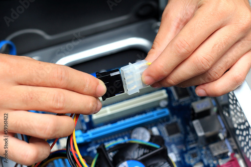 Closeup of a technician s hands wiring a computer mainboard
