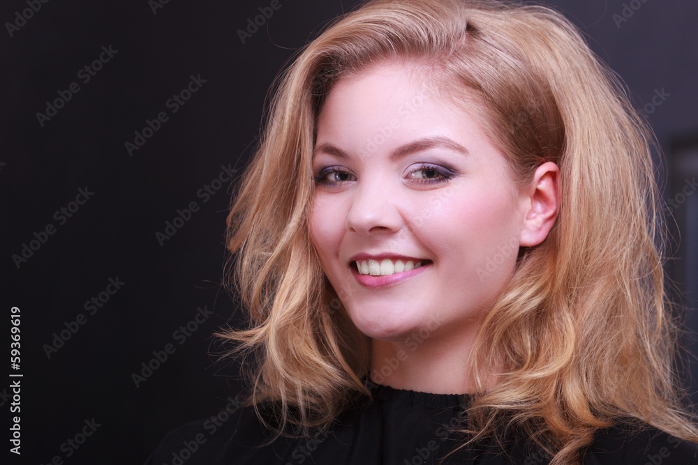 Smiling girl with blond wavy hair by hairdresser in beauty salon Smiling girl with blond wavy hair by hairdresser in beauty salon