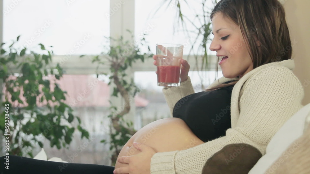 Portrait of pregnant woman drinking tomato juice, tracking shot Portrait of pregnant woman drinking tomato juice, tracking shot