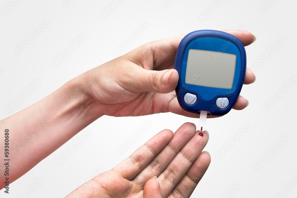 Woman doing blood sugar test Woman doing blood sugar test