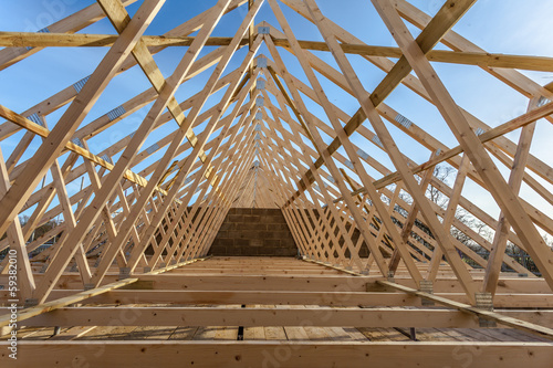 Wood house truss against blue sky  photo