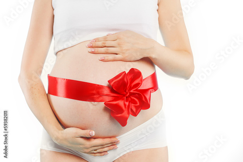 Wallpaper Mural Portrait of pregnant woman a tiny pair of red shoes for a child Torontodigital.ca