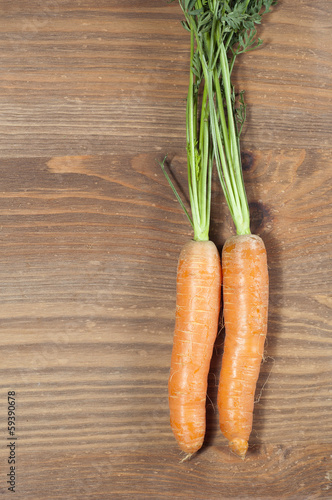 Bunch of carrots in the kitchen, on a wooden table background