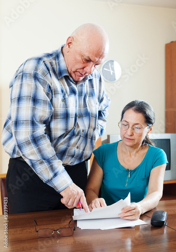 Mature couple fills in questionnaire together