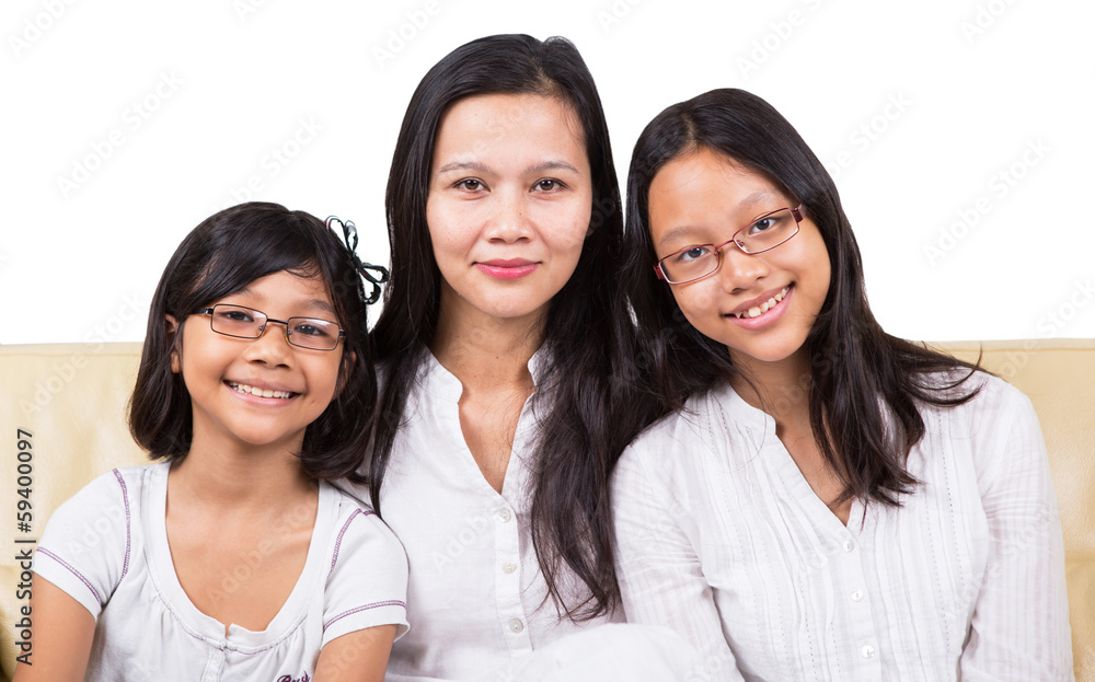 Mother and two daughters relaxing on a sofa Mother and two daughters relaxing on a sofa