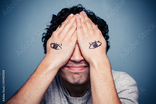 Man with eyes painted on his hands photo