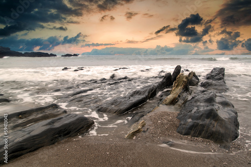 Landscape seascape of jagged and rugged rocks on coastline with photo