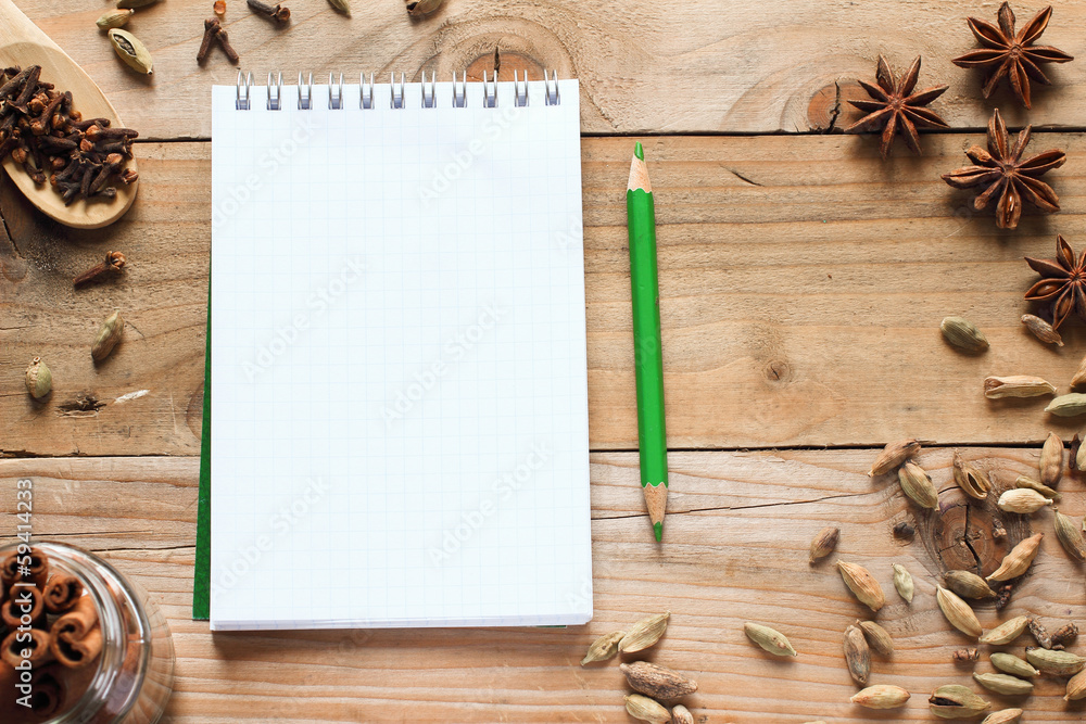 Notebook with green pencil and aromatic spices Notebook with green pencil and aromatic spices