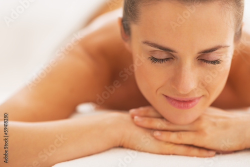 Portrait of relaxed young woman laying on massage table