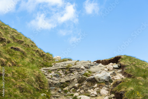 Close view of a mountain trail over blue sky with copy space