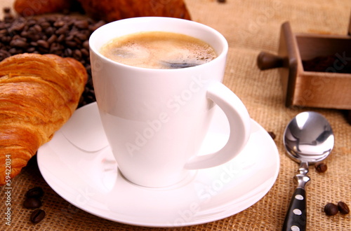 Coffee in white cup and croissant