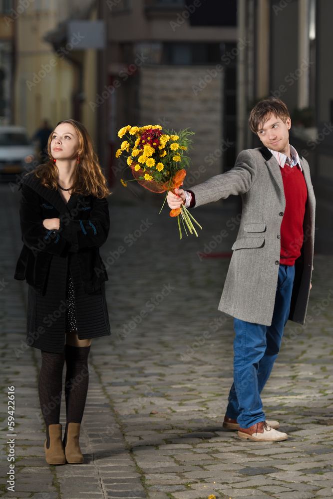 Fototapeta premium young man giving flowers to his date