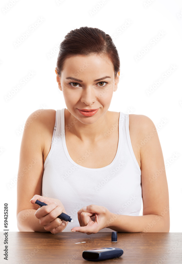 Beautiful young taking sugar blood test. Beautiful young taking sugar blood test.