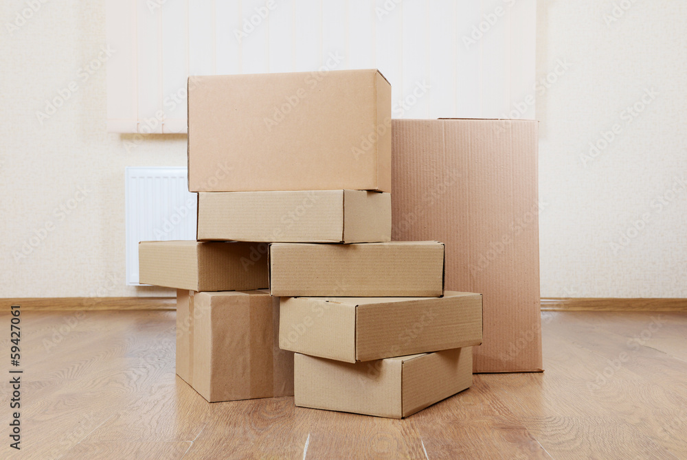 Empty room with stack of cartons: moving house concept Empty room with stack of cartons: moving house concept