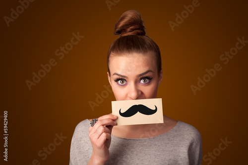 Happy cute girl holding paper with mustache drawing