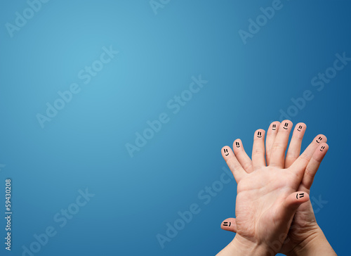 Happy smiley face fingers looking at empty blue background copy
