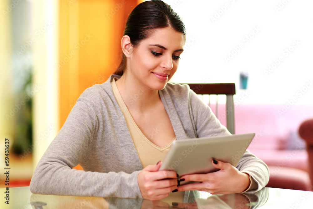 Young smiling woman holding tablet computer at home Young smiling woman holding tablet computer at home