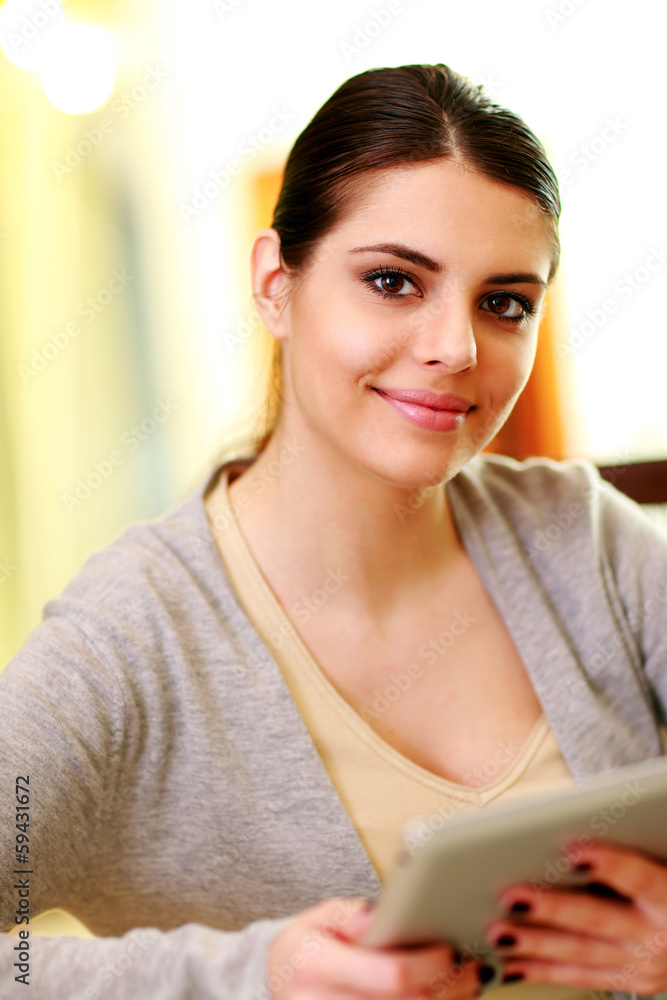 Closeup portrait of a woman holding tablet computer at home