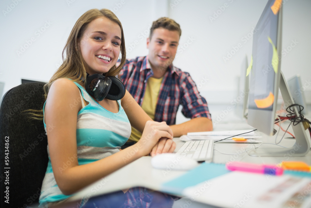 Cheerful classmates doing assignment together in the computer ro Cheerful classmates doing assignment together in the computer ro