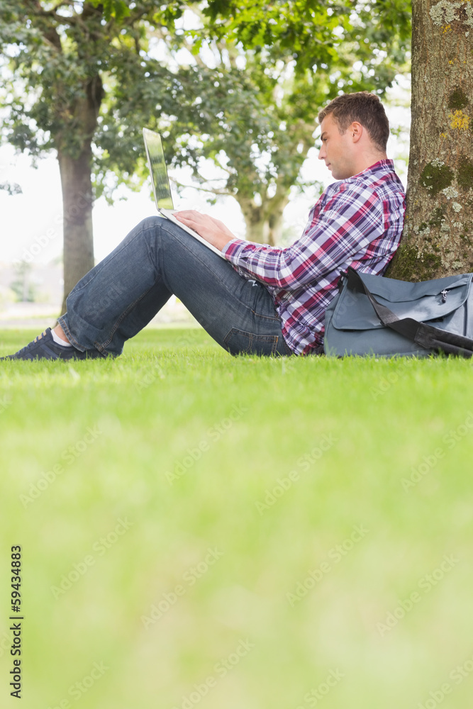 Student using his laptop to study outside Student using his laptop to study outside