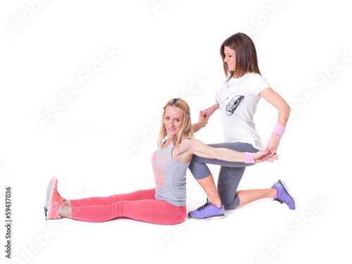 Two young women doing yoga stretching exercises