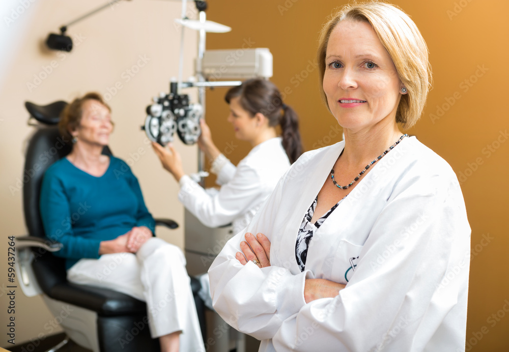 Confident Ophthalmologist With Colleague Examining Patient Confident Ophthalmologist With Colleague Examining Patient