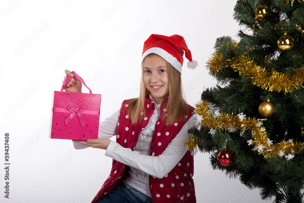 girl with gifts near a Christmas tree girl with gifts near a Christmas tree