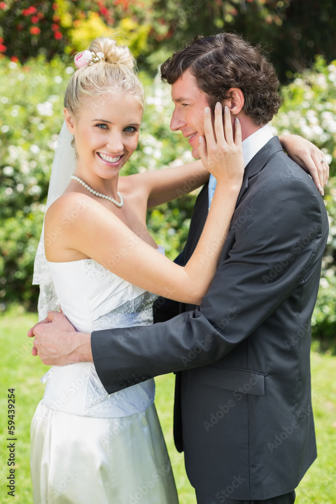 Happy wife touching her new husbands cheek smiling at camera Happy wife touching her new husbands cheek smiling at camera