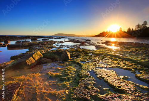 Photography Golden Sunrays stretch across the reefs at sunset