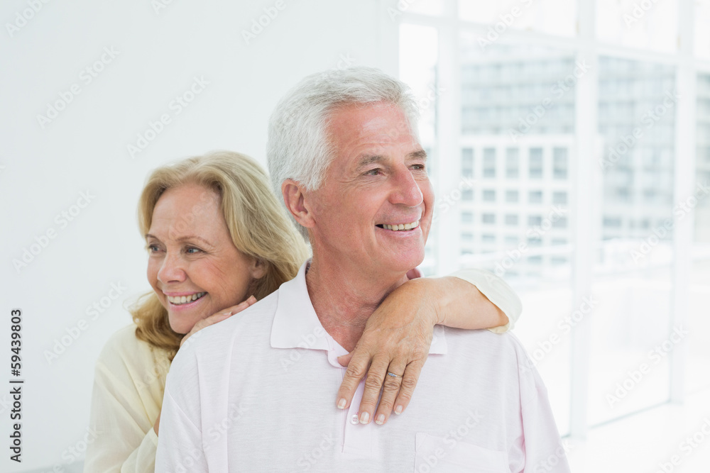 Happy senior woman embracing man from behind Happy senior woman embracing man from behind