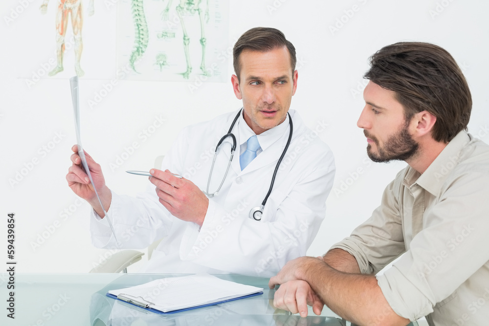 Male doctor explaining spine x-ray to patient Male doctor explaining spine x-ray to patient