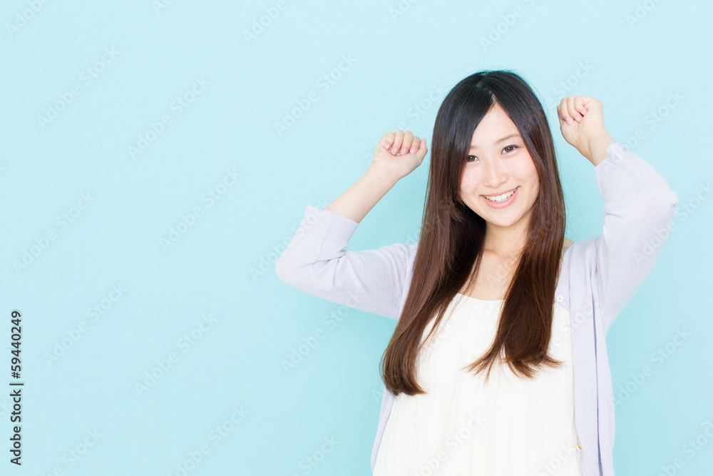 young asian woman cheering on blue background young asian woman cheering on blue background