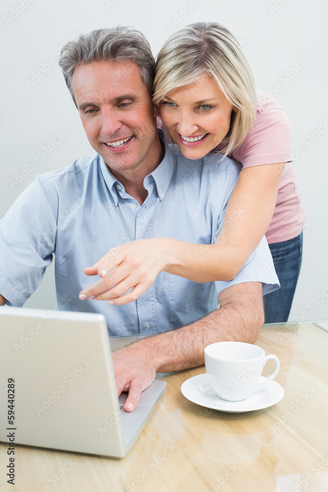 Casual couple using laptop at home Casual couple using laptop at home