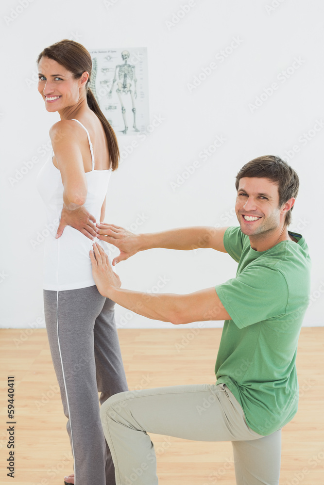Fototapeta premium Physiotherapist examining woman's back in medical office