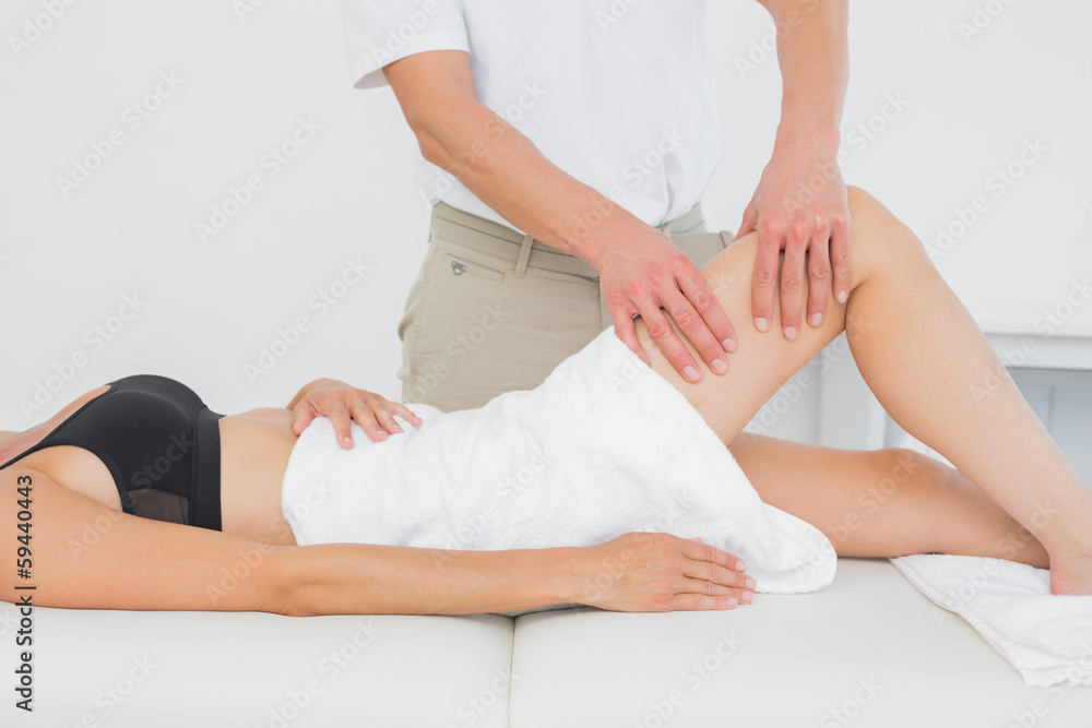 Fototapeta premium Physiotherapist examining a young woman's leg