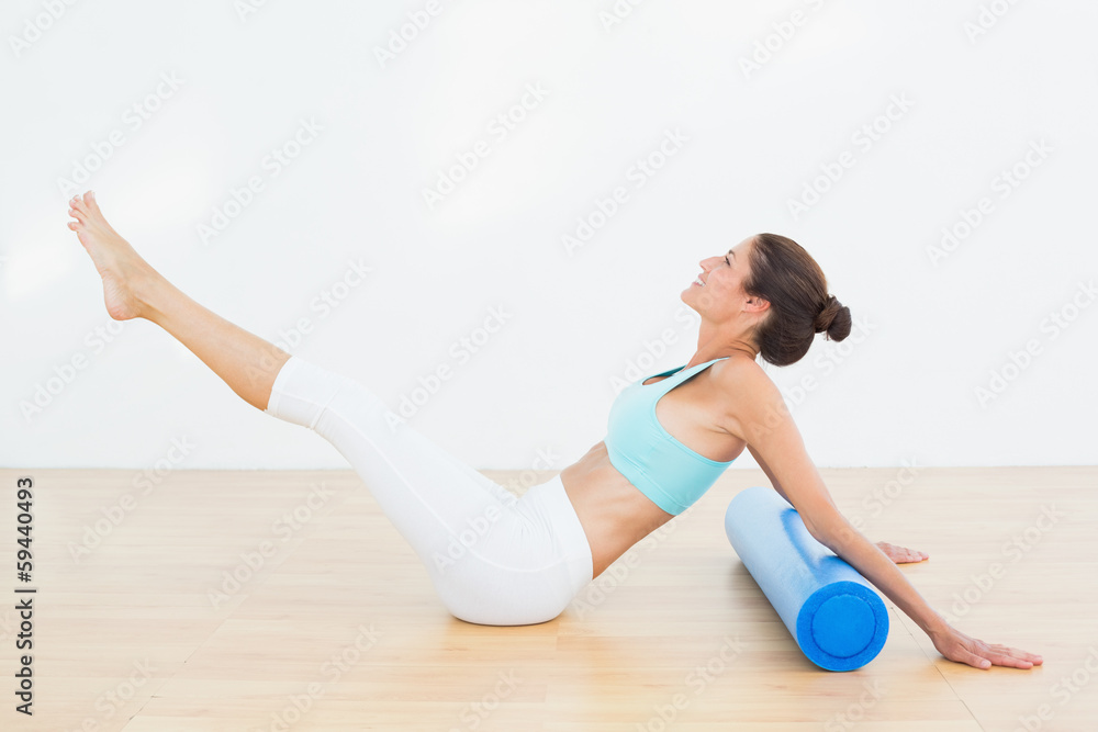 Naklejka premium Toned woman doing the boat pose in fitness studio