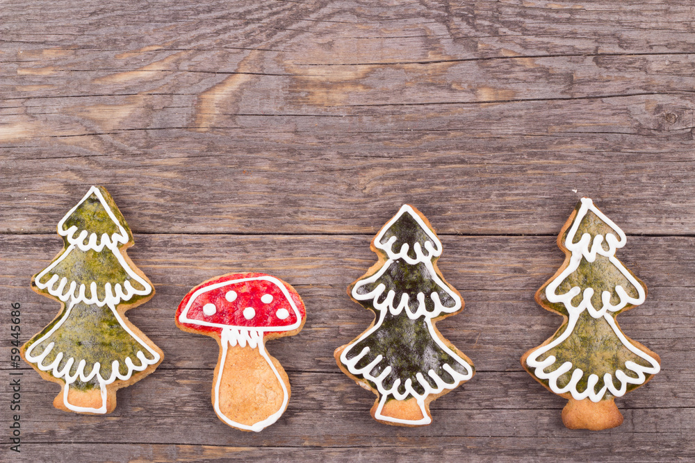 Gingerbread cookies hanging over wooden background Gingerbread cookies hanging over wooden background