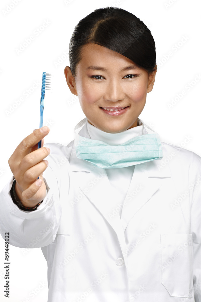smiling young asian woman dentist showing a toothbrush smiling young asian woman dentist showing a toothbrush