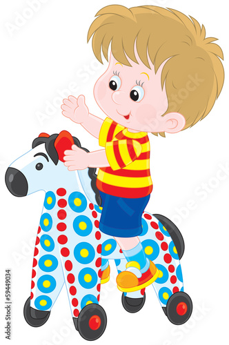 Little boy riding on a colorful toy horse