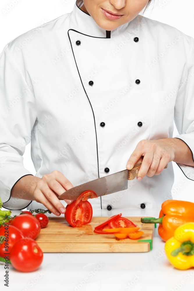 Beautiful young woman cook cutting fresh tomatoes Beautiful young woman cook cutting fresh tomatoes