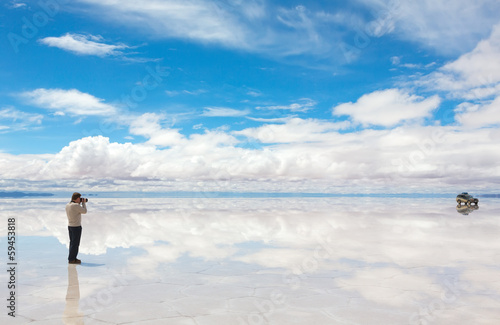 Man taking pictures on the lake Salar de Uyuni