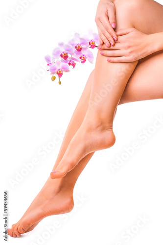 female legs and pink manicure with orchid flower