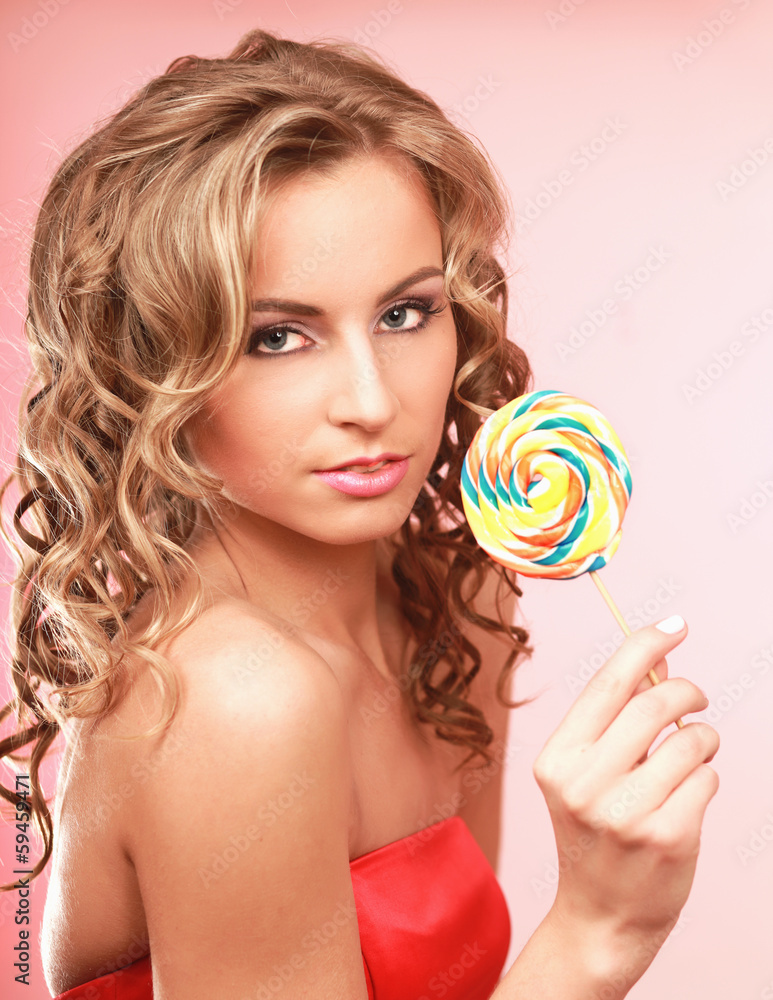 young happy woman with lollipop, isolated on pink background