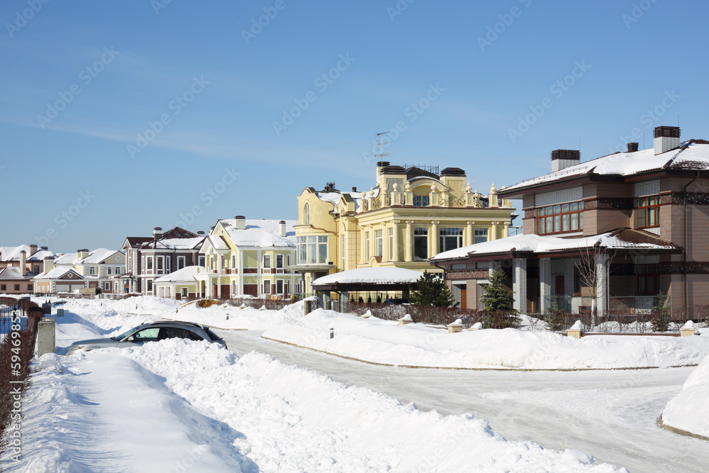 Street with lots of snow drifts in small cottage settlements
