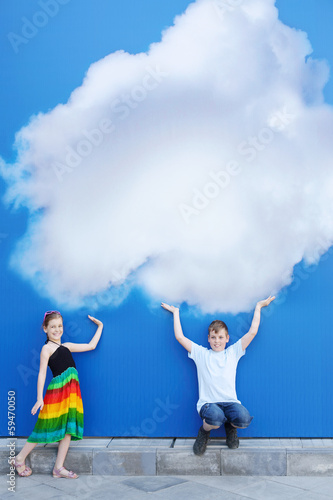 Brother and sister hold large painted at blue wall cloud