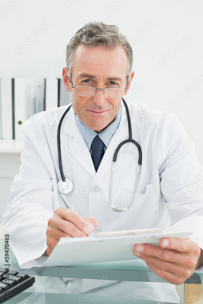 Portrait of a doctor writing a report at office Portrait of a doctor writing a report at office