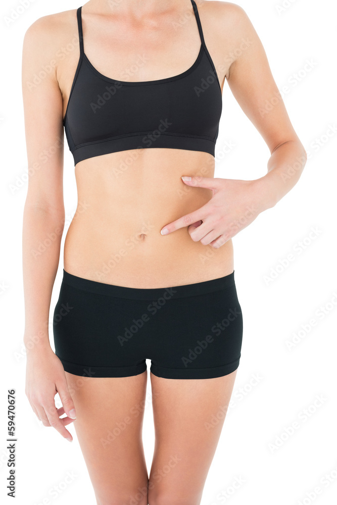 Close-up mid section of a fit woman with hand on stomach Close-up mid section of a fit woman with hand on stomach