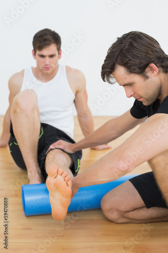 Physical therapist examining a young mans leg