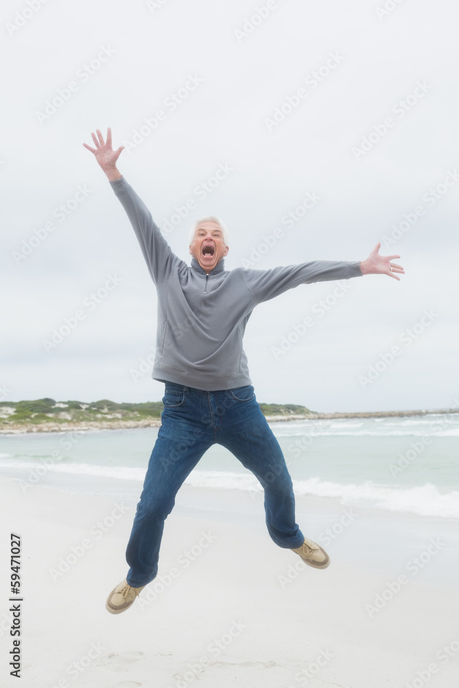 Full length of a senior man jumping at beach Full length of a senior man jumping at beach